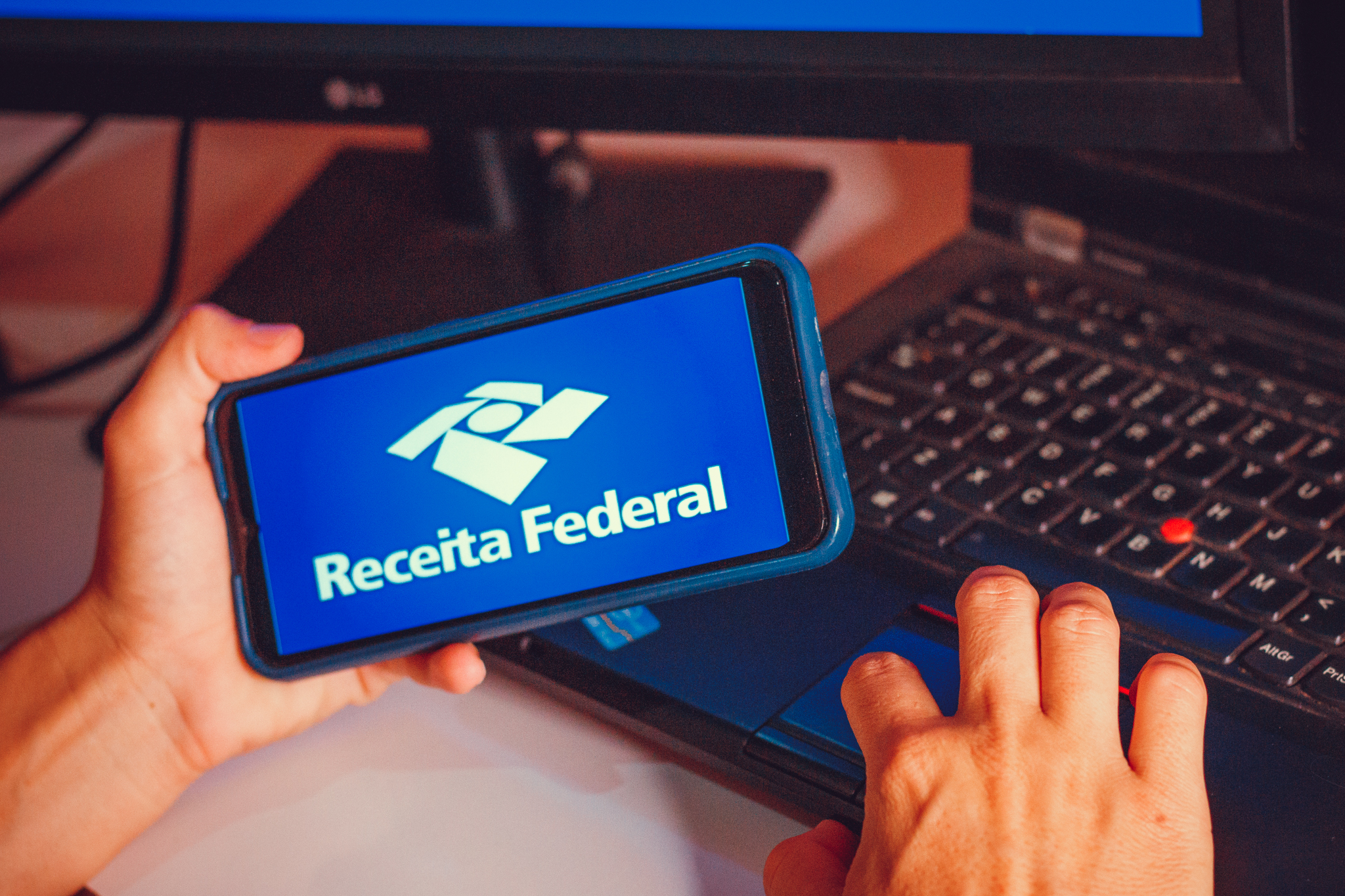 Celular e um teclado com a imagem da Receita Federal