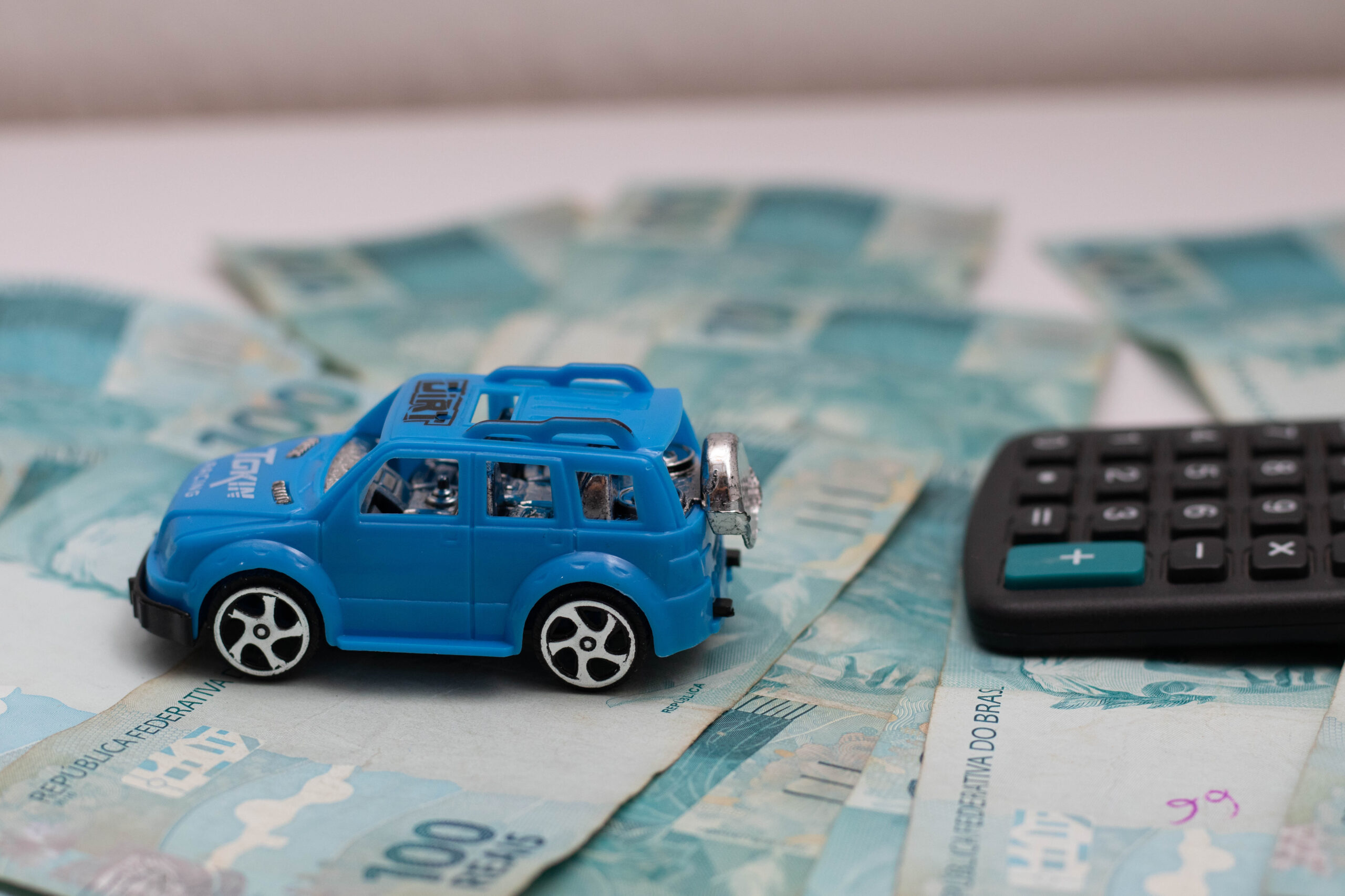 Carro de brinquedo e cédulas de dinheiro