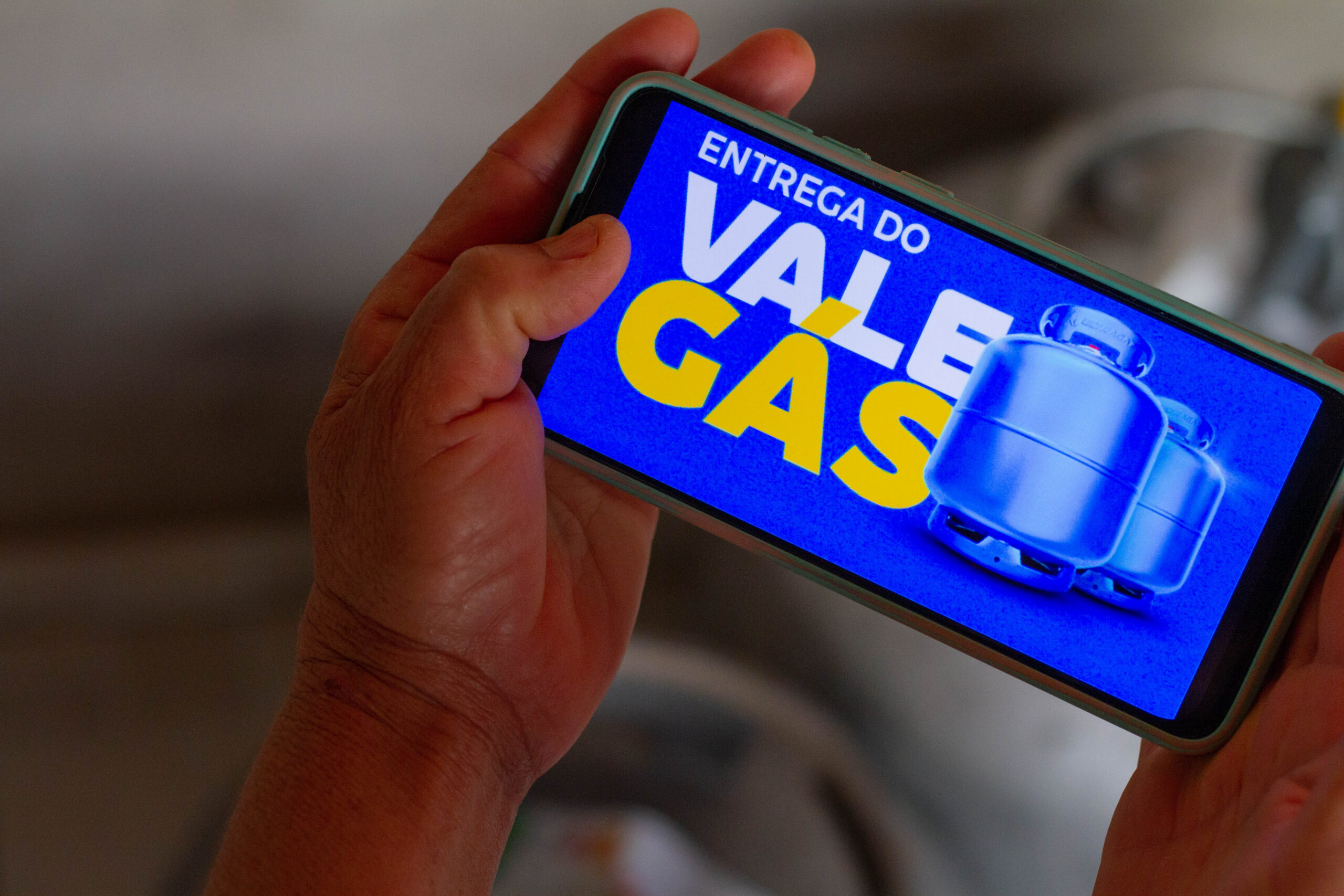 Celular com uma imagem escrita 'Entrega do Vale Gás'