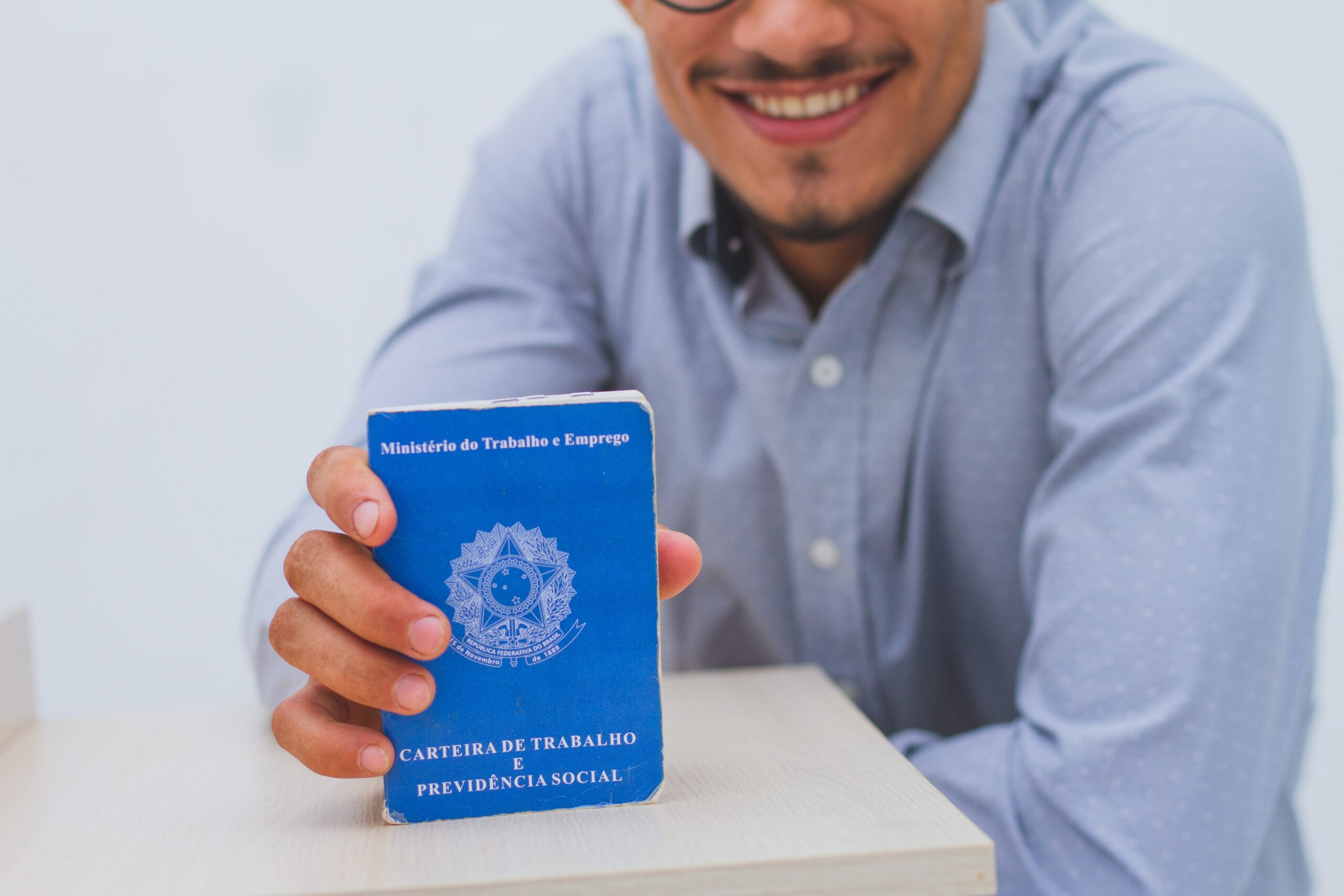 Pessoa segurando uma carteira de trabalho em suas mãos