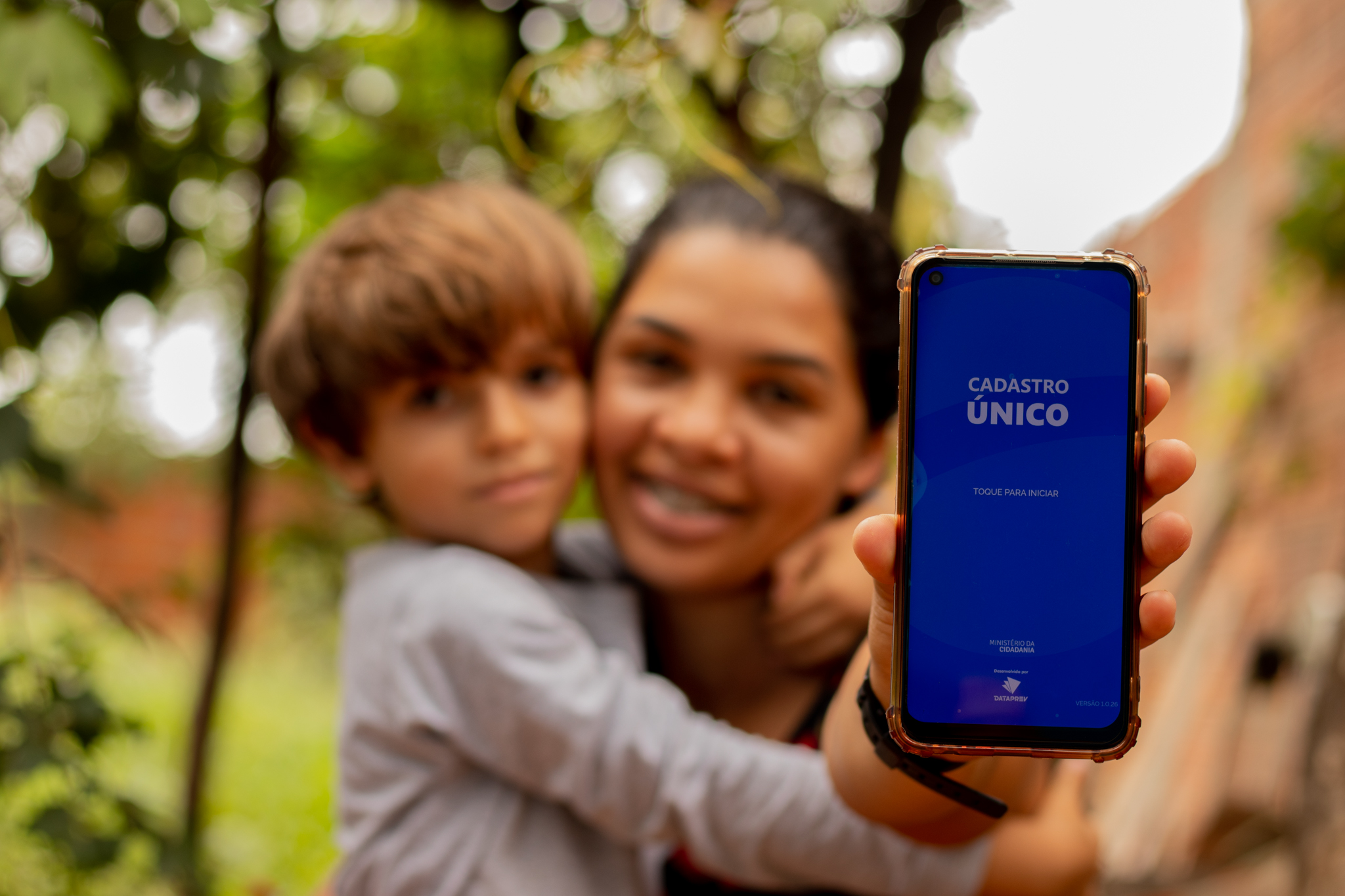 Mãe e seu filho segurando celular nas mãos