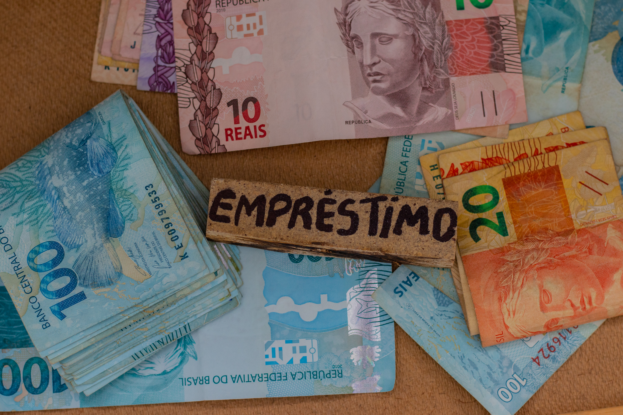 Várias cédulas de dinheiro brasileiro e o nome empréstimo