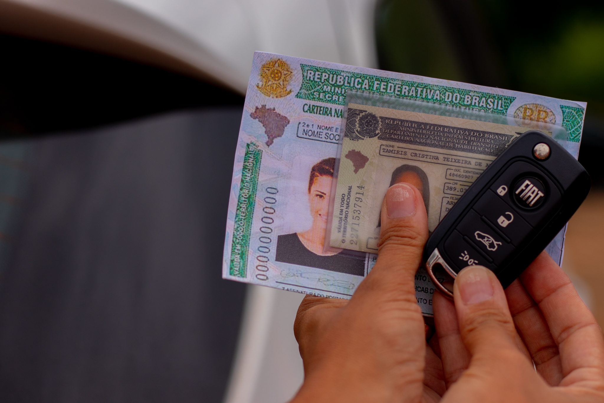 Pessoa segurando CNH em suas mãos
