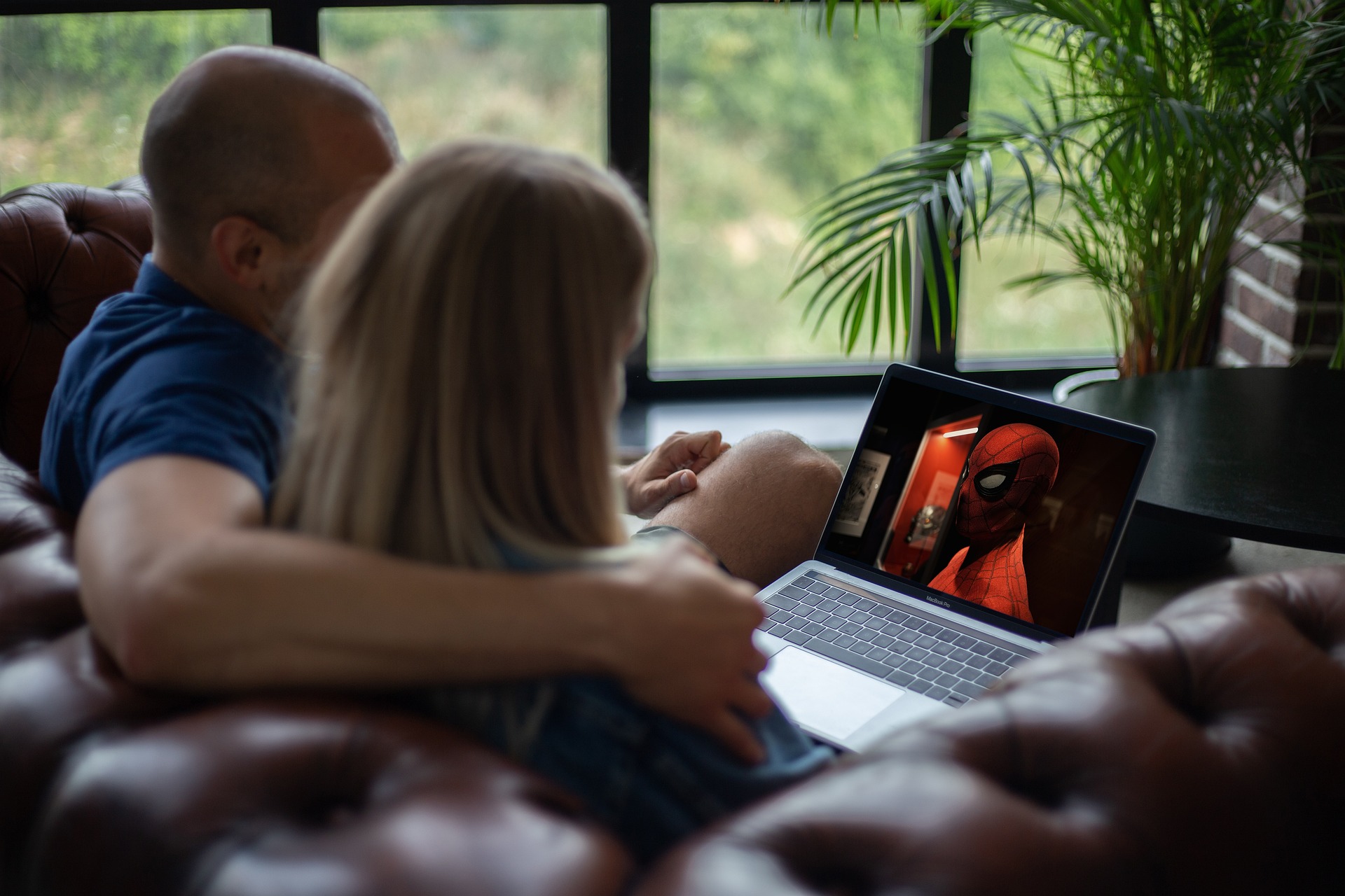 Um casal assistindo filmes e séries de graça pelo notebook