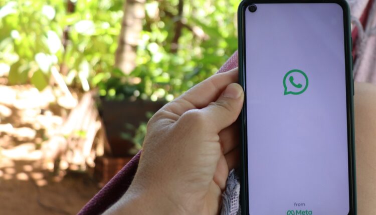 Pessoa segurando celular aberto no WhatsApp