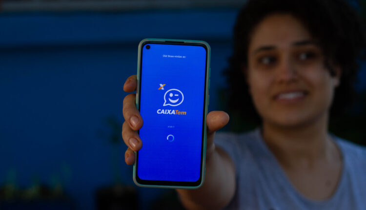 Pessoa segurando celular no Caixa Tem