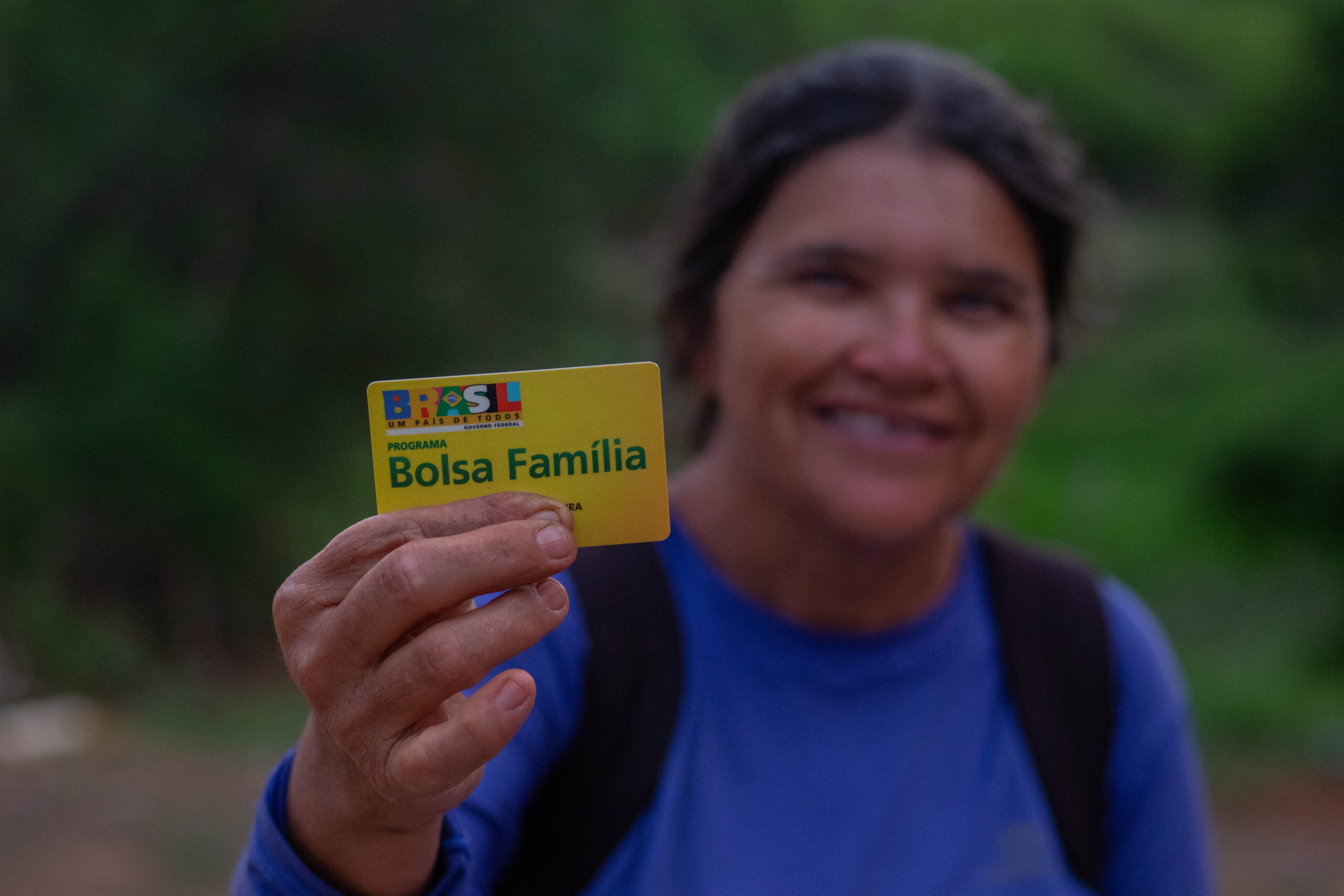 Pessoa segurando cartão do Bolsa Família