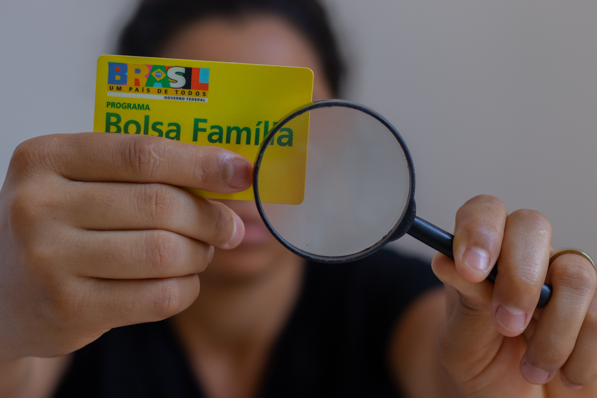 Pessoa segurando cartão do Bolsa Família