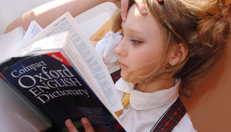 Menina e dicionário de inglês