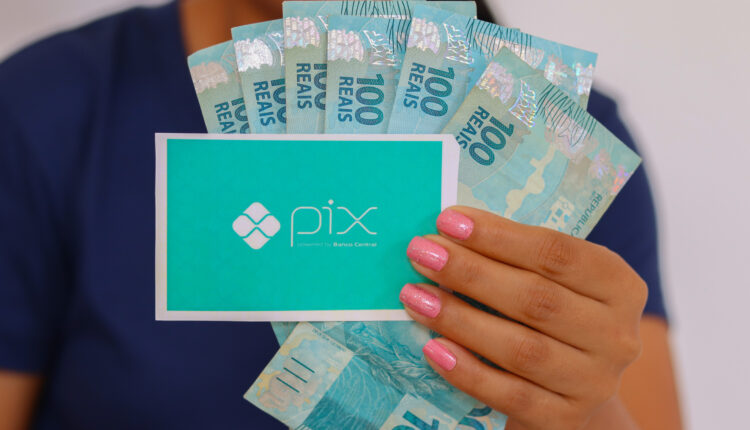 Símbolo do Pix e cédulas de dinheiro brasileiro