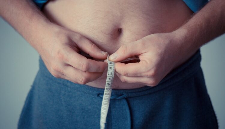 Pessoa medindo o tamanho da barriga