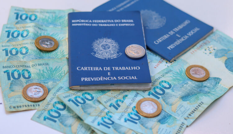 Carteira de trabalho e cédulas de dinheiro brasileiro