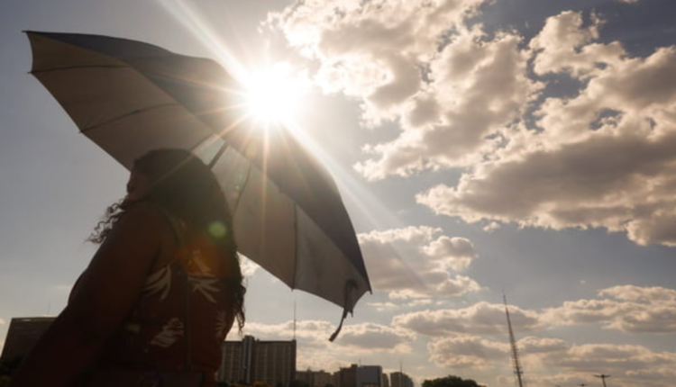 Mulher com guarda-chuva embaixo do Sol forte.