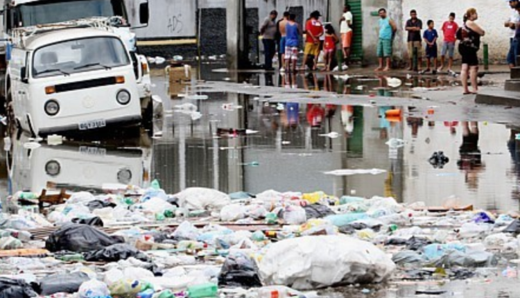Foto de uma rua poluída com lixos.