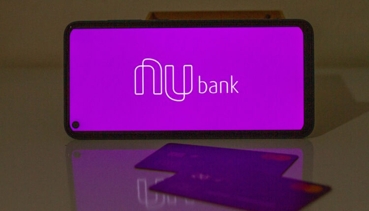 Celular deitado na horizontal em uma mesa, com a logo do Nubank.