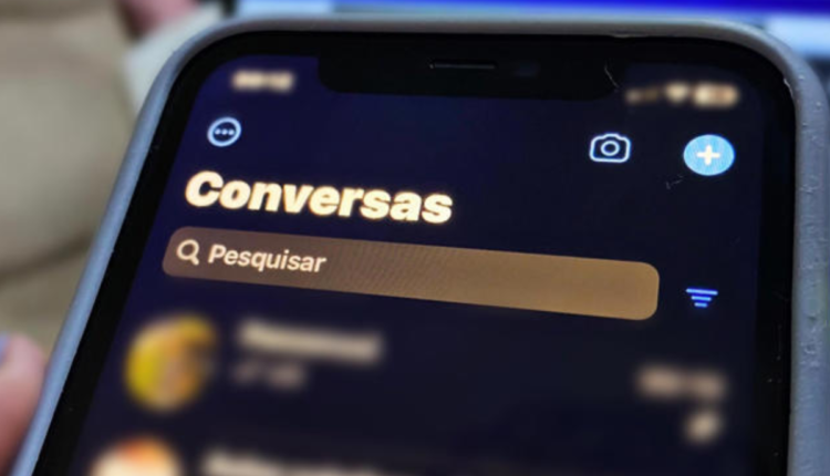 Celular com aba de conversas do WhatsApp.