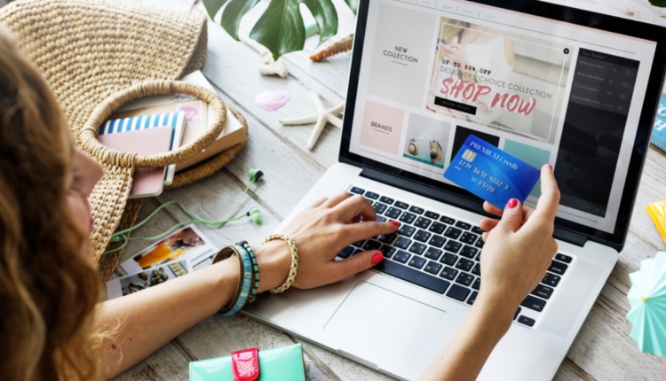 Pessoa realizando compras online, por meio do notebook.