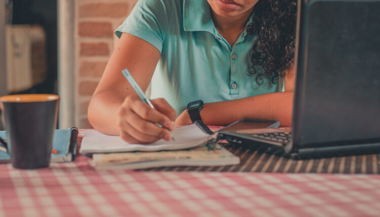 Mulher estudando para concurso em mesa.