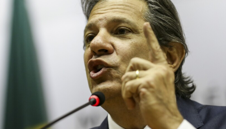 Foto de Haddad em um microfone.