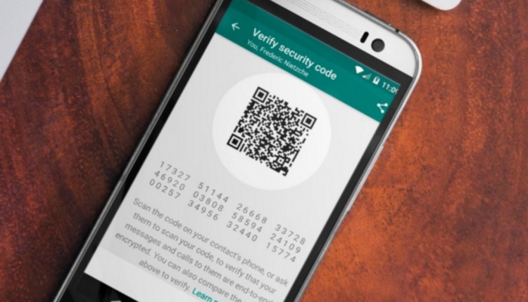 Celular em mesa, tela mostrando app do WhatsApp.