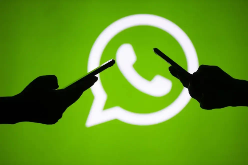 Logo do WhatsApp ao fundo com dois celulares.