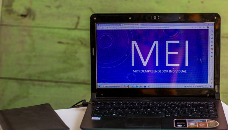 Notebook aberto com logo do MEI.