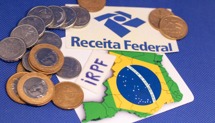 Moedas em cima de mesa, com logo do IRPF.