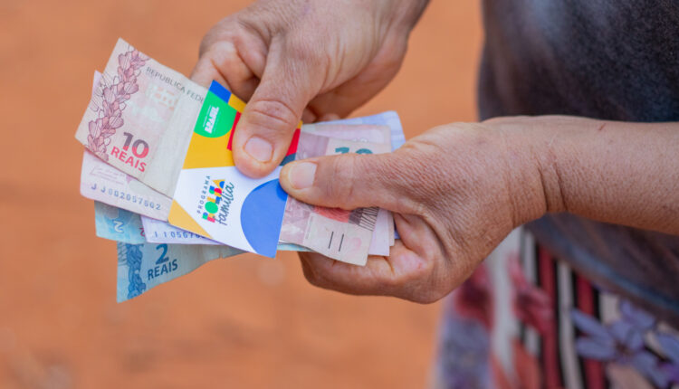 Pessoa segurando cartão Bolsa Família.