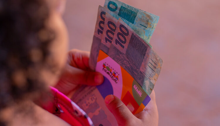 Pessoa segurando cartão do Bolsa Família.