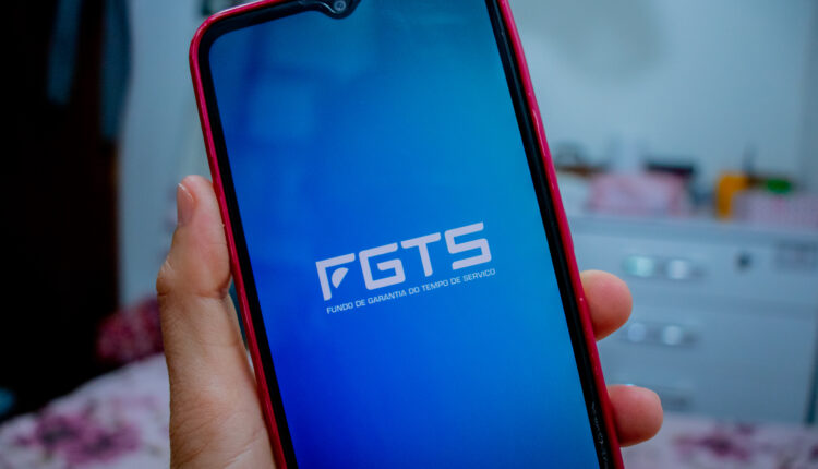 Celular com a logo do FGTS em tela.