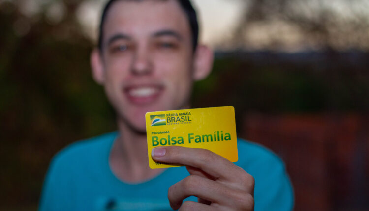 Homem segurando cartão do Bolsa Família.