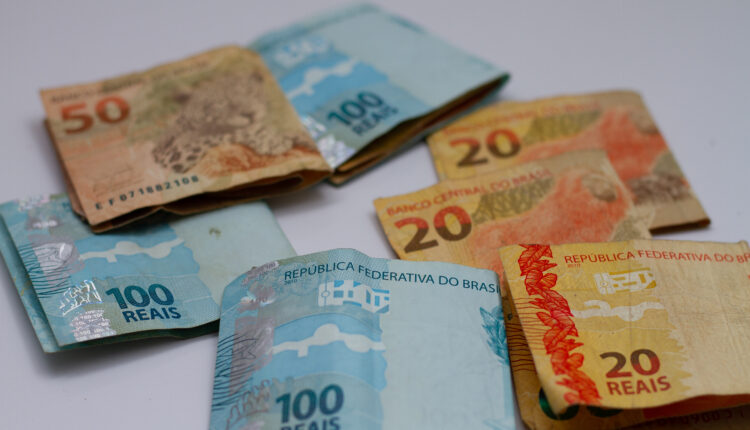 Notas de dinheiro em cima de mesa.