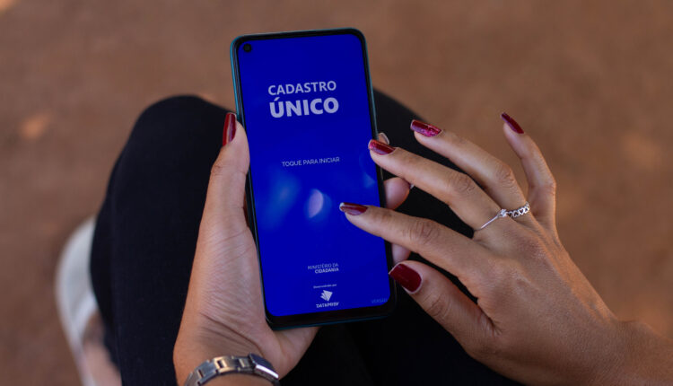Pessoa mexendo no app Cadúnico.