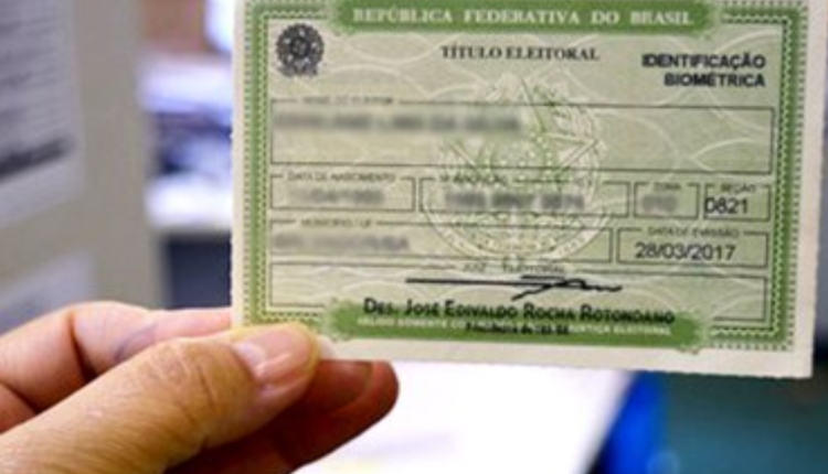 Homem segurando Título de Eleitor na mão.