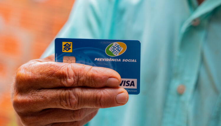 Pessoa segurando cartão da Previdência Social.