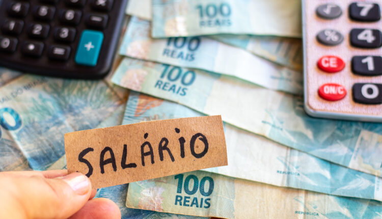 Notas distribuídas em mesa com calculadora.