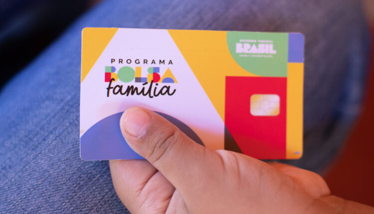 Pessoa segurando cartão do Bolsa Família.