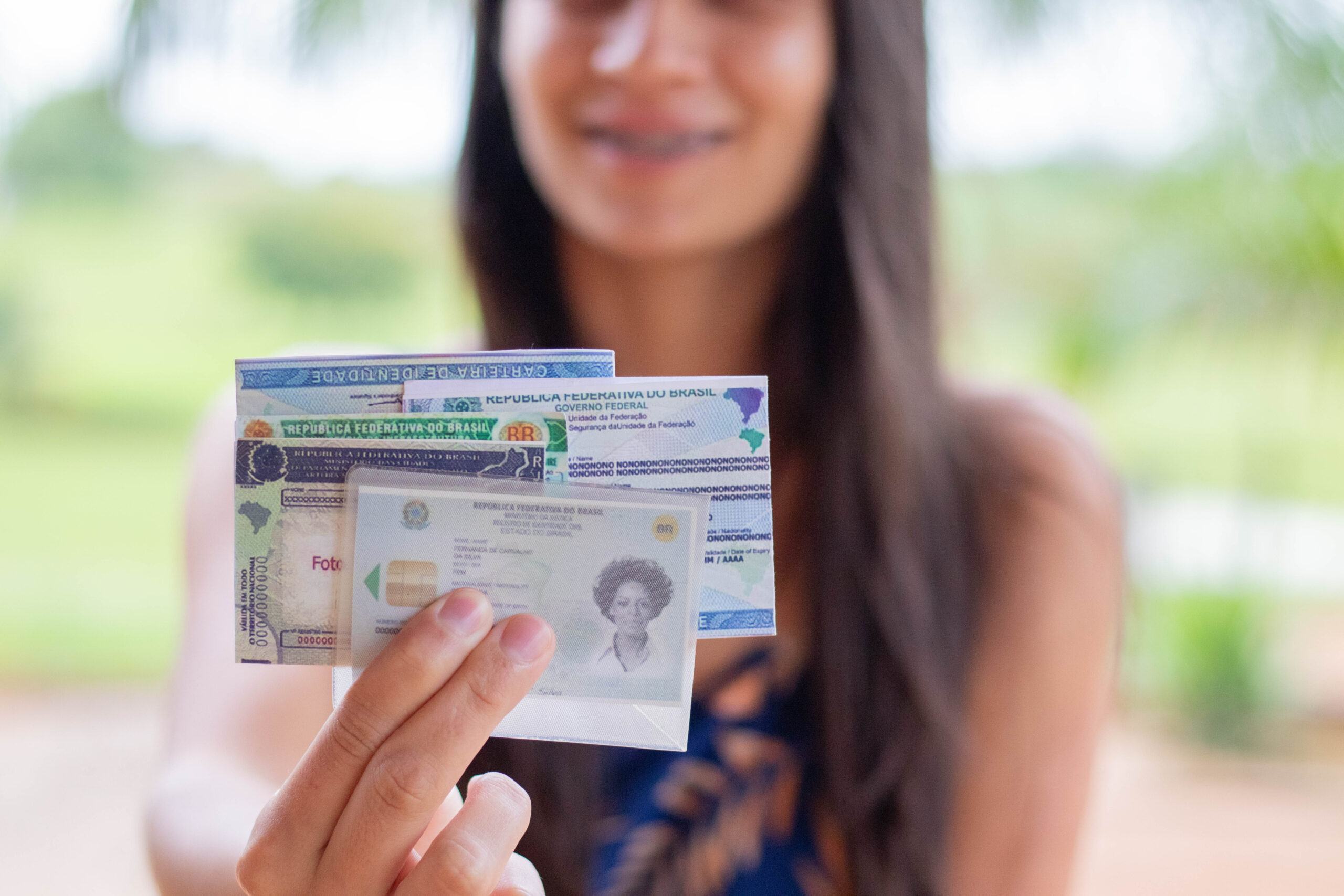 Mulher segurando vários documentos, incluindo o RG.