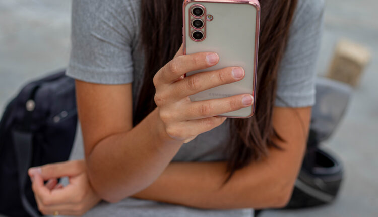 Mulher mexendo no celular.