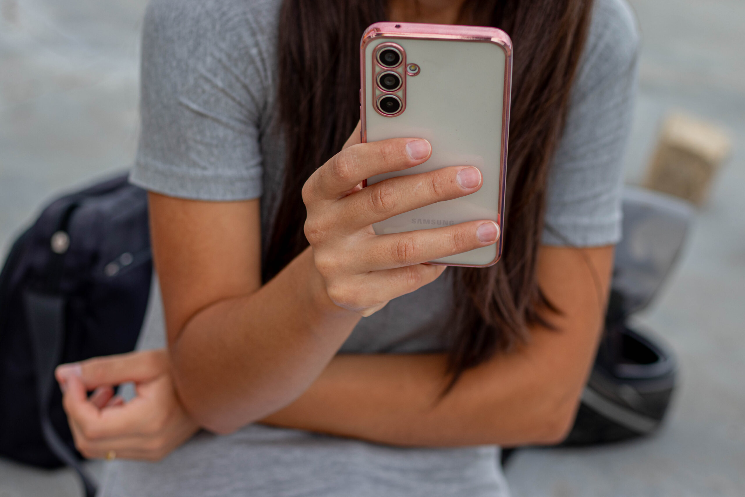 Mulher mexendo no celular.