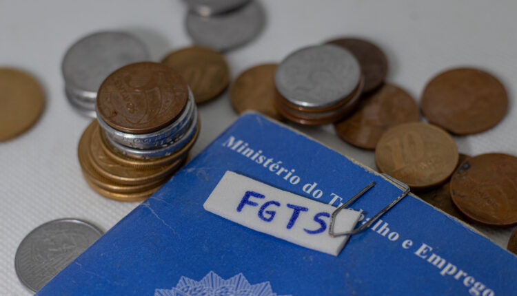 Moedas e carteira de trabalho.