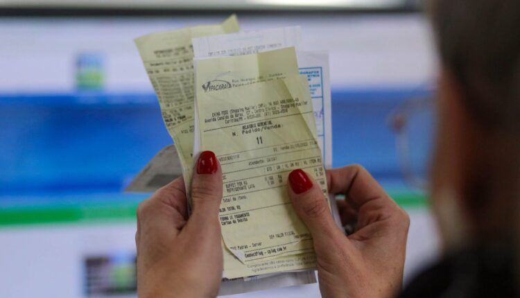 Mão segurando nota fiscal