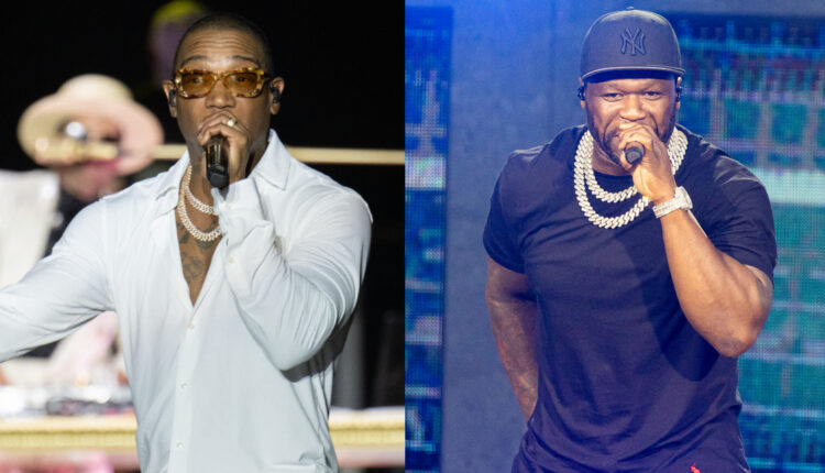 Ja Rule in a white shirt performing, and 50 Cent in a black shirt and cap, both holding microphones on stage.