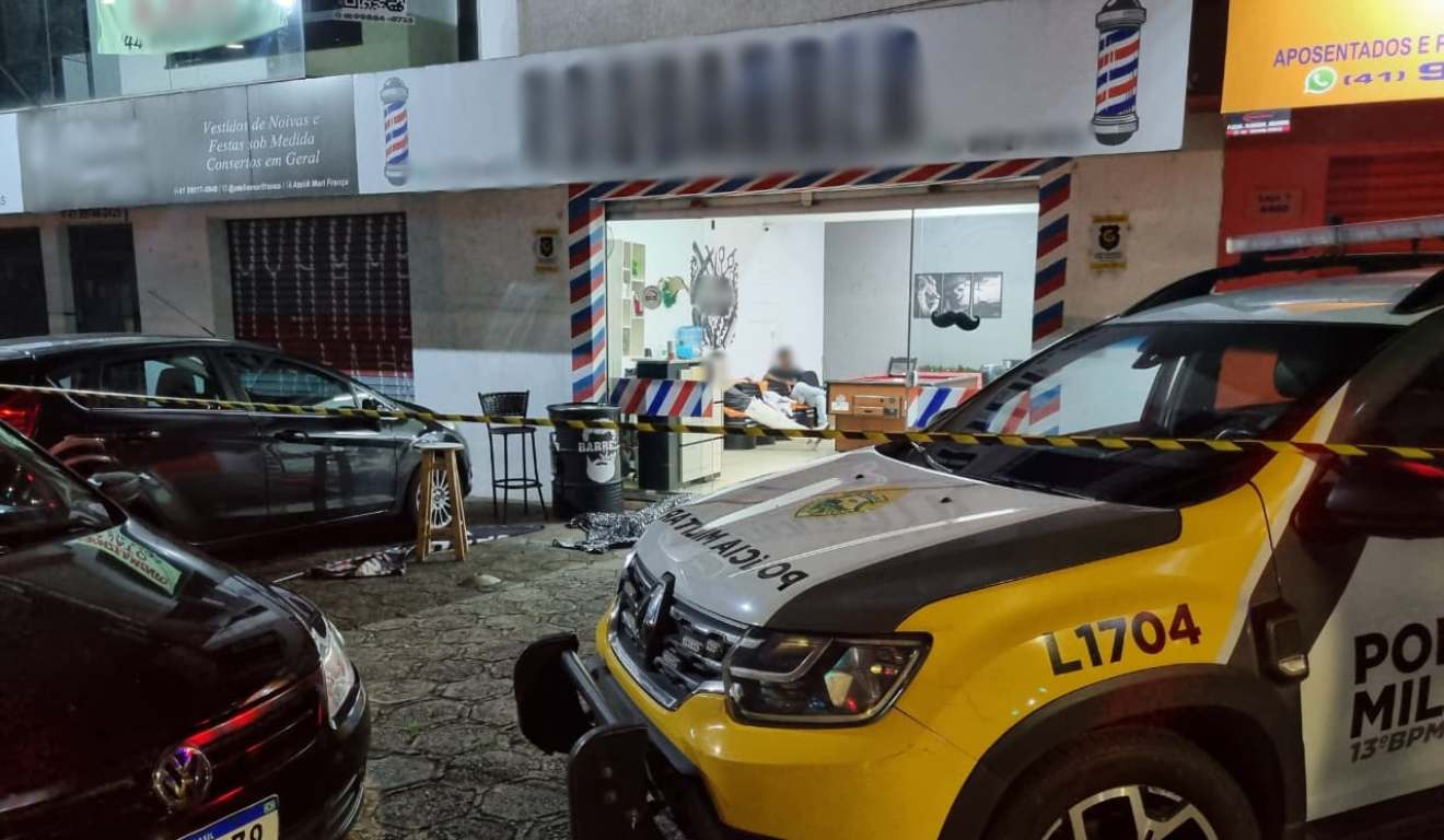 Viatura da polícia militar em frente a barbearia onde mulher foi morta a facadas