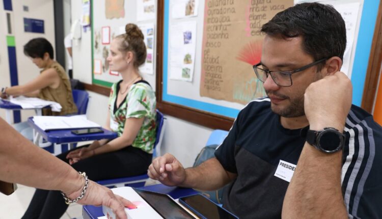 Mesário observa eleitor cadastrar biometria; Voluntário precisa se inscrever para participar da eleição